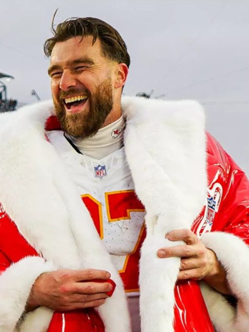 Person wearing a red and white sports jersey with a fur-lined coat, smiling outdoors.