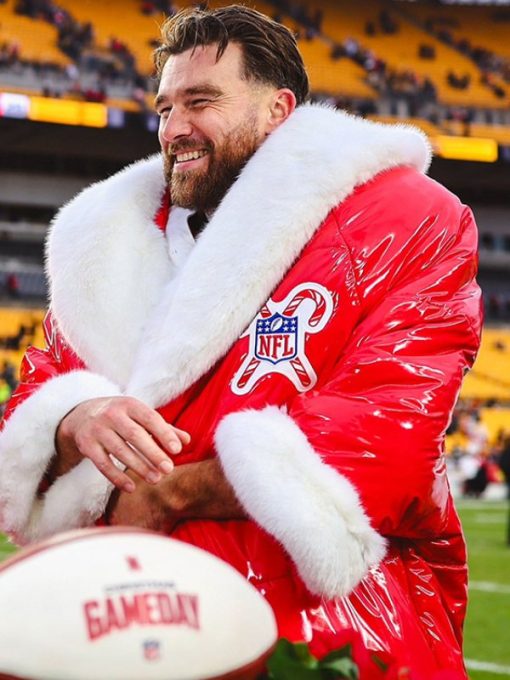 Person wearing a red NFL jacket with white fur trim, sitting on a football field.