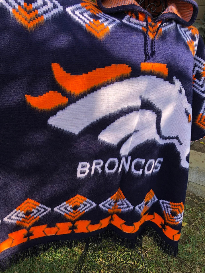 Knitted blanket with Denver Broncos logo on grass