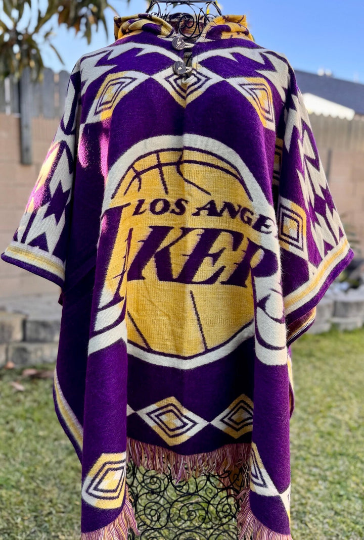 Los Angeles Lakers-themed poncho with purple, yellow, and white colors on a grassy outdoor background.