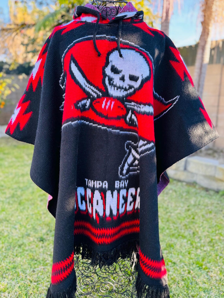 Piracy-themed poncho with skull and crossbones design in red and black, worn outdoors.