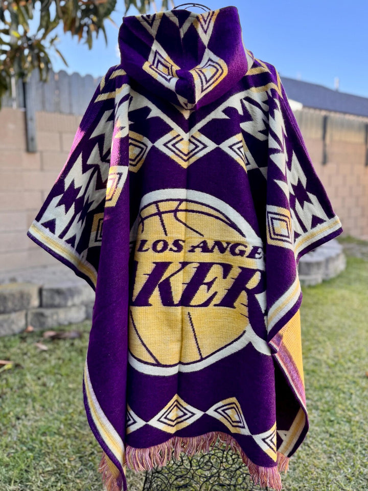 Purple and gold Los Angeles Lakers poncho with tassels on a grassy background